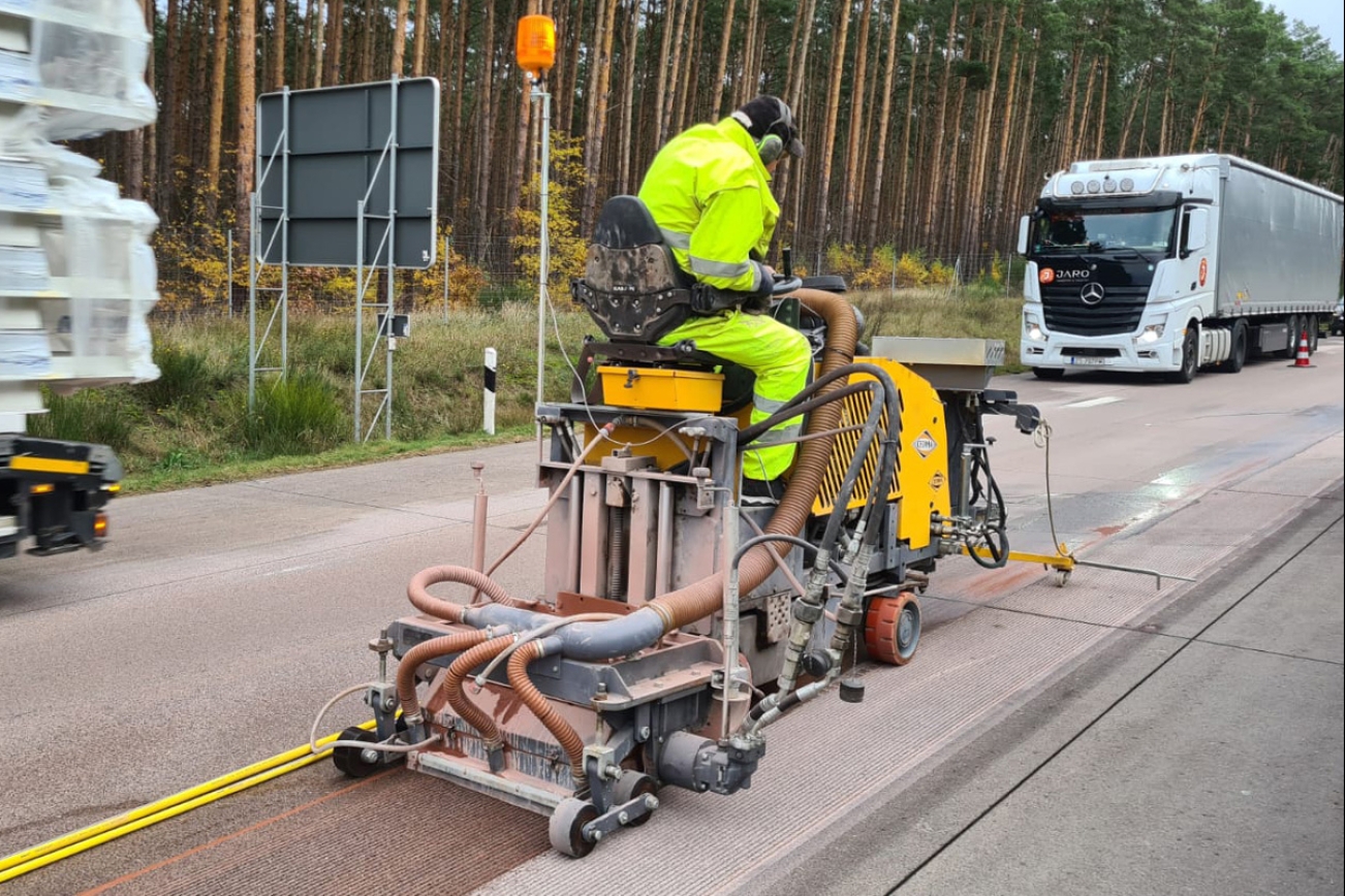Cedima Fugenschneider CF 6022 im Einsatz auf Strasse. Mit Bauarbeiter, der die Maschine steuert.