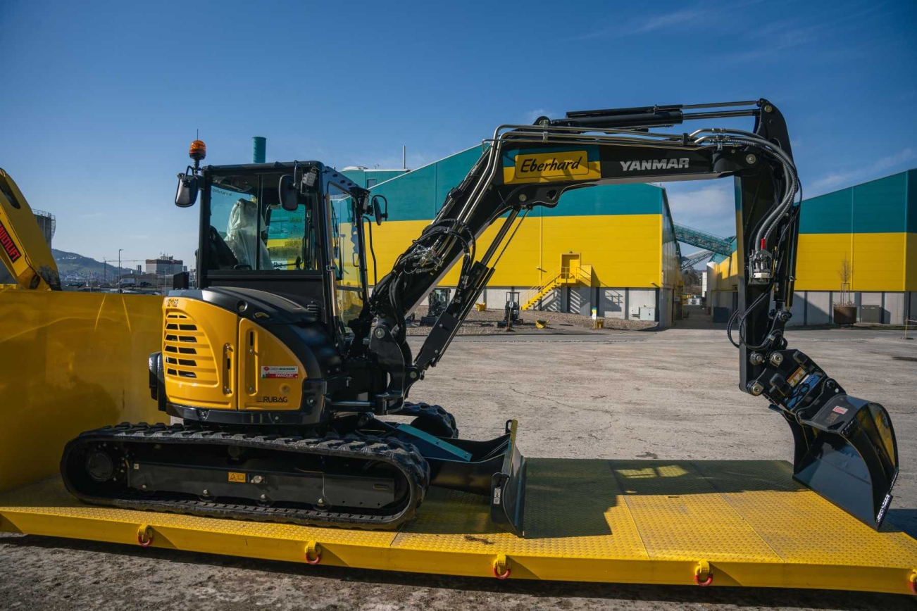 Gelber YANMAR Bagger vor Eberhard Gebäude